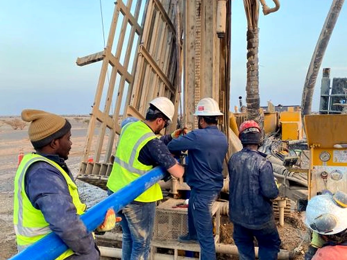 Drill crew handling casing pipe at the rig on site