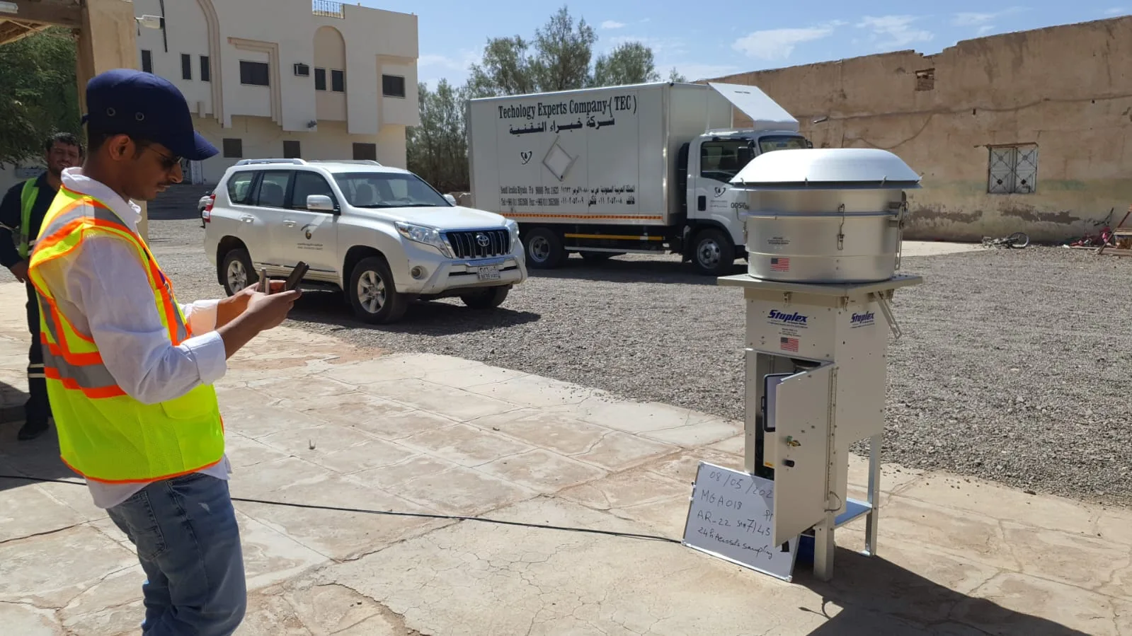 Technician operating an ambient air-quality sampler on site