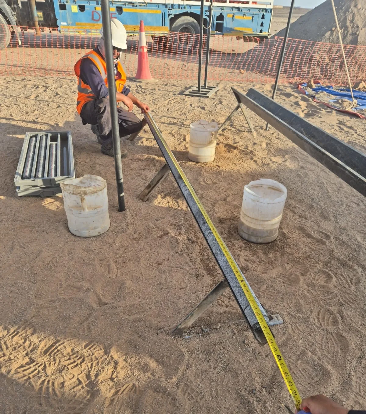 Measuring recovered core against the tape at the drill site