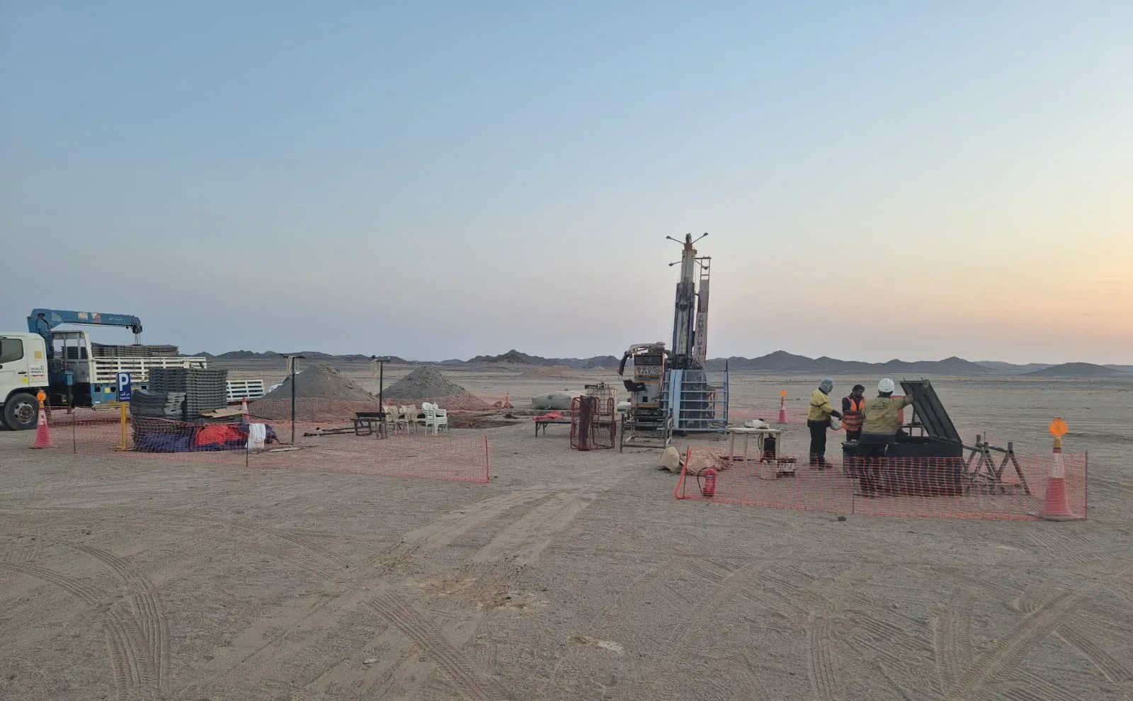Exploration drill rig and support trucks at the site