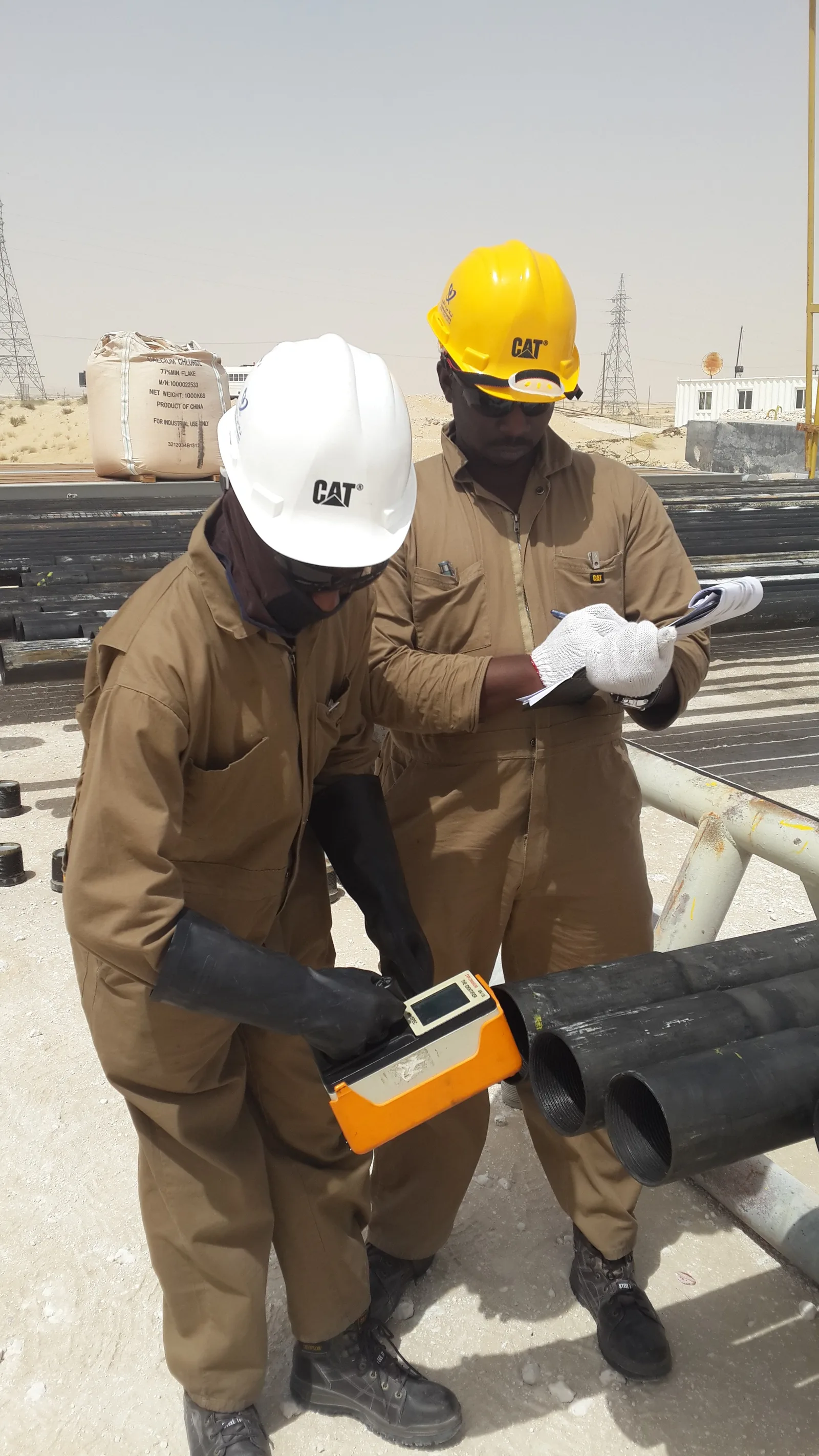 Technicians performing a radiological survey and wipe test on pipework